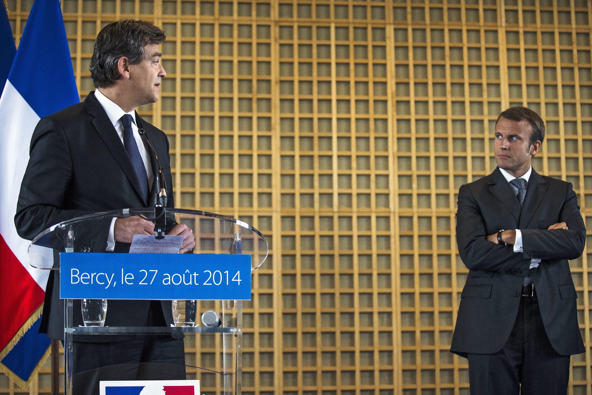 Amtsübergabe in Paris – Vorgänger Arnaud Montebourg ernennt Emmanuel Macron am 27. August 2014 zum Wirtschaftsminister: Macron stellt sich der Aufgabe und schafft es vier Jahre später Präsident zu werden. Noch wirkt er mit den verschränkten Armen ein wenig verschlossen.