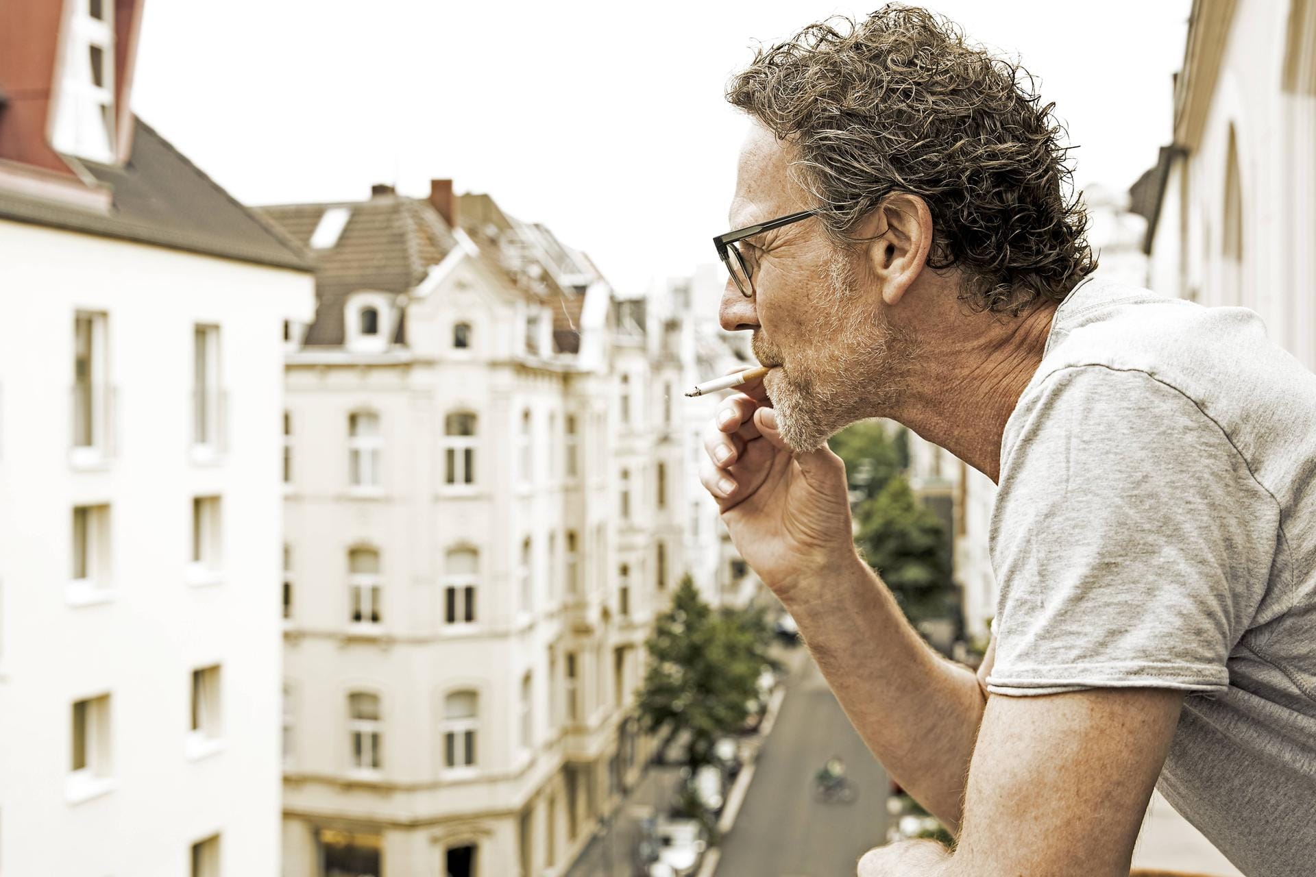 Mann raucht auf dem Balkon