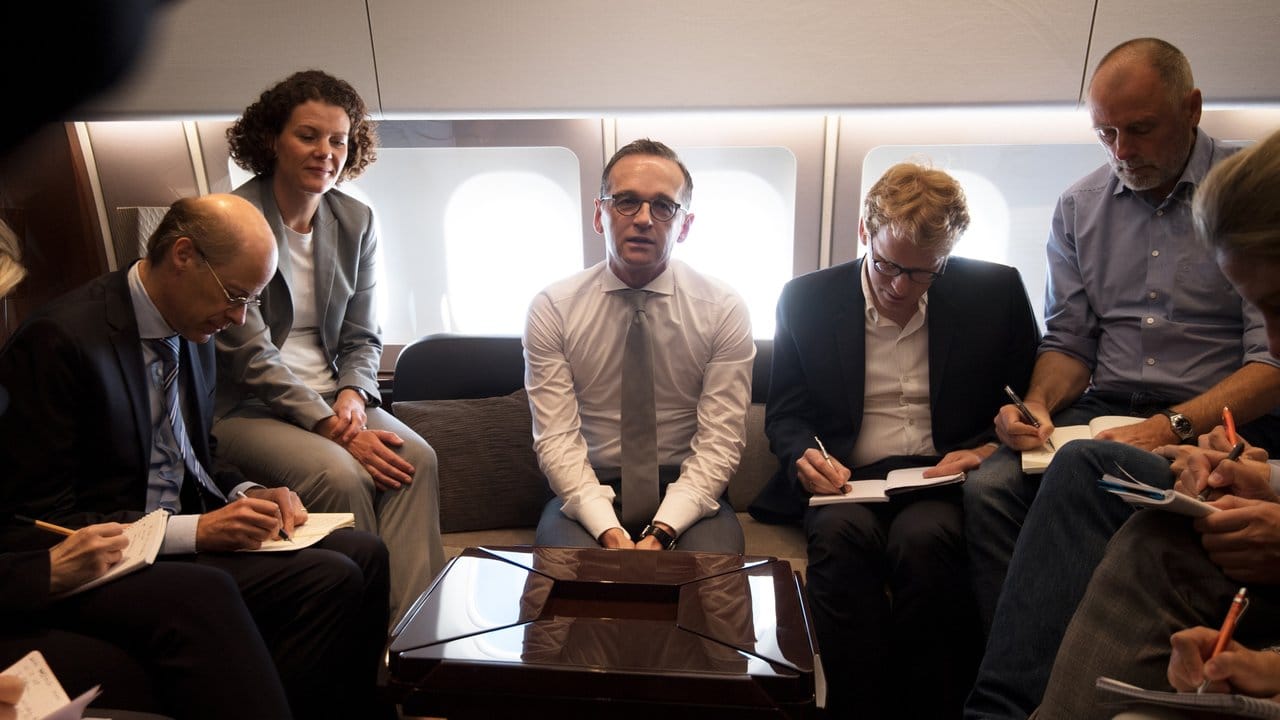Bundesaußenminister Heiko Maas (M) spricht vor seiner Ankunft in Moskau mit mitreisenden Journalisten.