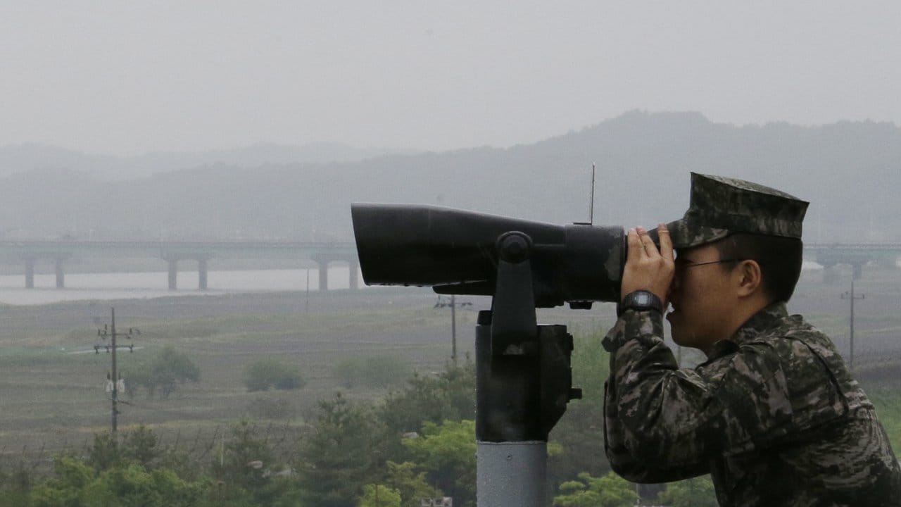 Ein Soldat der südkoreanischen Marine blickt durch ein Fernglas in Richtung Nordkorea. Ein Soldat der südkoreanischen Marine blickt durch ein Fernglas in Richtung Nordkorea.