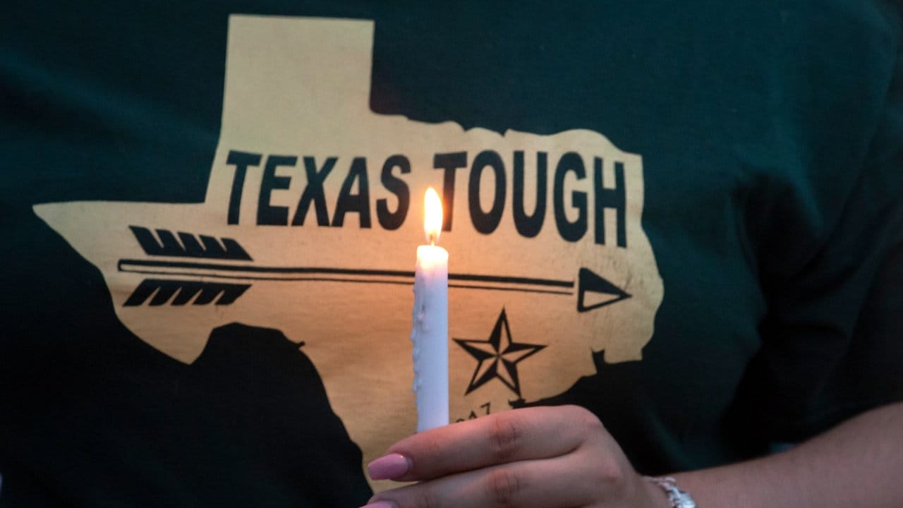 Eine Frau trägt ein T-Shirt mit der Aufschrift "Texas tough" (Texas ist zäh) während eines öffentlichen Gebetes in Santa Fe. Eine Frau trägt ein T-Shirt mit der Aufschrift "Texas tough" (Texas ist zäh) während eines öffentlichen Gebetes in Santa Fe.
