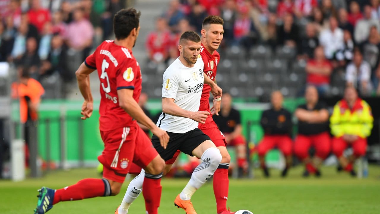 Bayerns Niklas Süle (r) und Mats Hummel setzten den Frankfurter Ante Rebic (M) unter Druck.