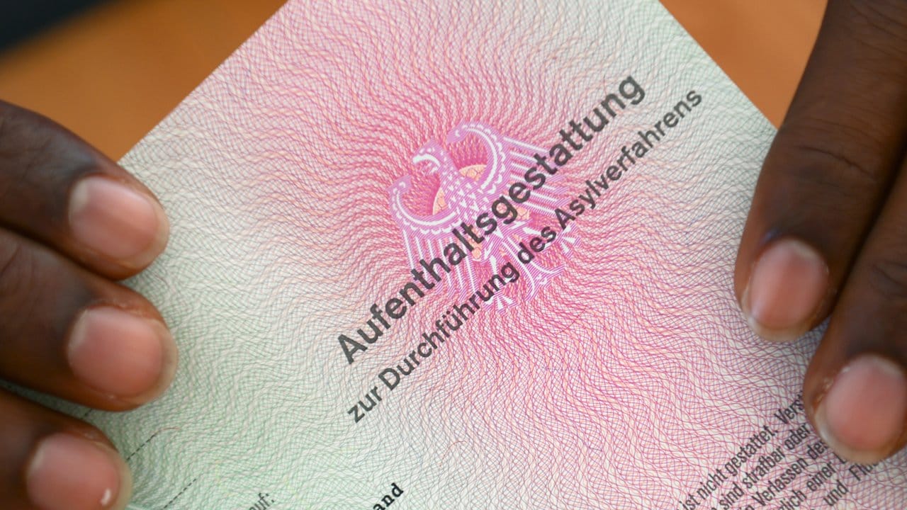 Er hat es geschafft: Ein somalischer Flüchtling hält eine Aufenthaltsgestattung in den Händen. Er hat es geschafft: Ein somalischer Flüchtling hält eine Aufenthaltsgestattung in den Händen.