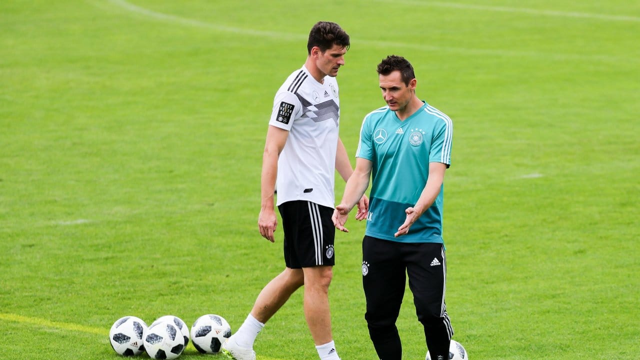 Assistenztrainer und DFB-Rekord-Torjäger Miroslav Klose (r) beim Austausch mit Angreifer Mario Gomez.