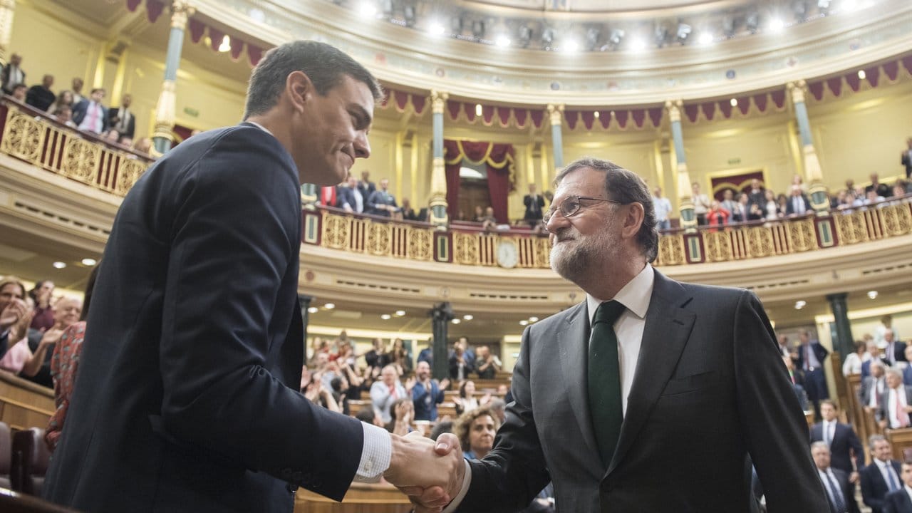 Der neue und der alte Ministerpräsident: PSOE-Chef Pedro Sánchez (l) und der konservative Mariano Rajoy reichen sich nach der Abstimmung im Parlament die Hand.