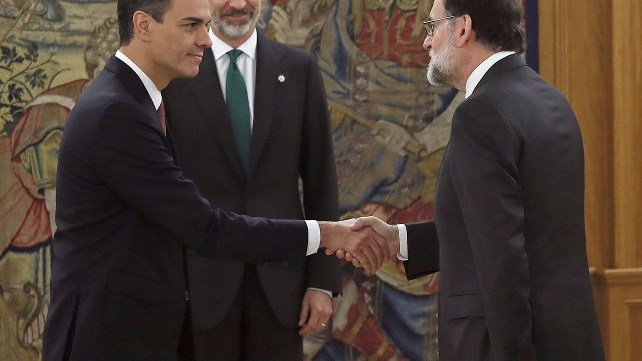 Mariano Rajoy (r) gratuliert seinem Nachfolger Pedro Sánchez bei der Amtseinführung in Anwesenheit von König Felipe von Spanien (M) im Zarzuela-Palast.