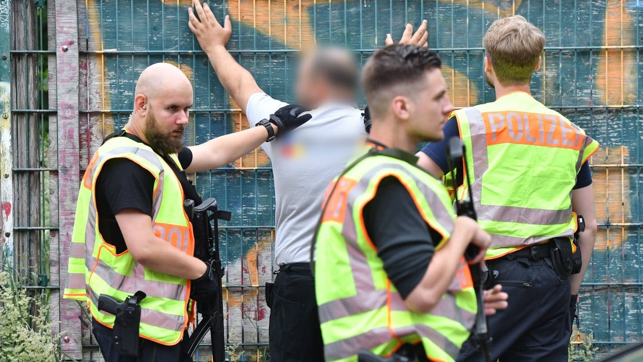 Polizisten durchsuchen eine Mann an einer Berliner Grundschule im Bezirk Mitte. Polizisten durchsuchen eine Mann an einer Berliner Grundschule im Bezirk Mitte.