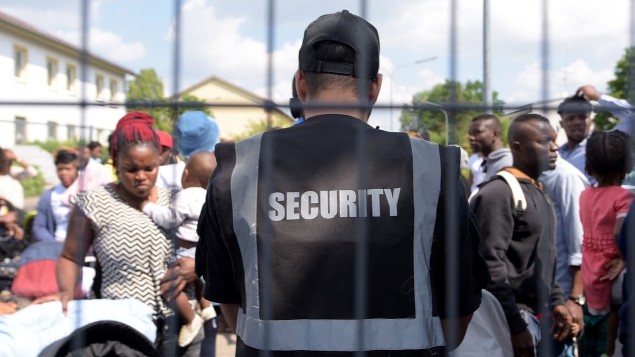 Konfrontation: Im Transitzentrum für Asylsuchende in Manching steht eine Sicherheitskraft Flüchtlingen gegenüber.