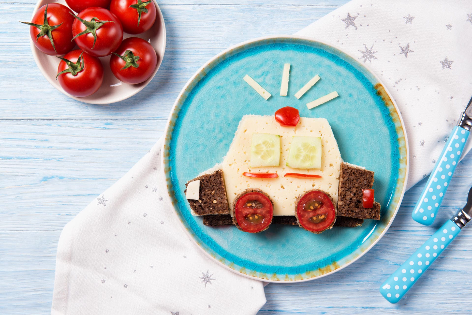 Lustig-Sandwich in der Form eines Polizeiautos: Sie brauchen dazu nur Schwarzbrot, Käse und Tomaten- sowie Gurkenscheiben.