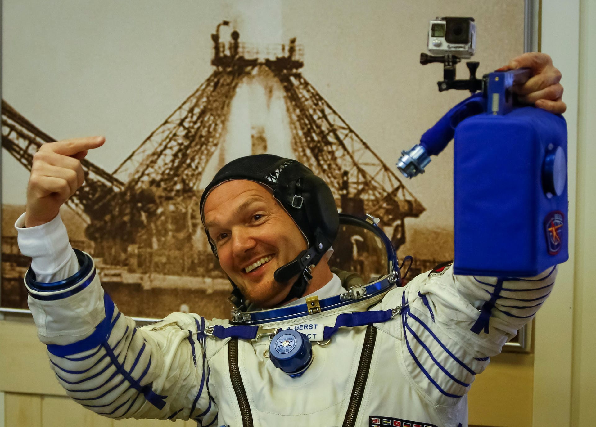 Auch im sperrigen Raumanzug hat "Astro-Alex" noch gute Laune. Der blaue Kanister ist seine Mini-Klimaanlage für den Raumanzug. Oben drauf hat Alexander Gerst eine GoPro-Kamera montiert – für Aufnahmen im Cockpit.
