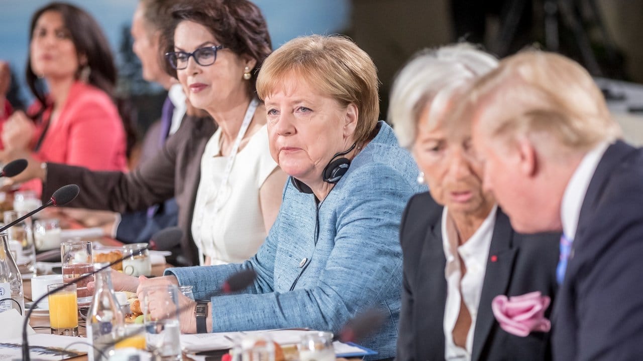 Mit scheinbar leerem Blick sitzt Bundeskanzlerin Angela Merkel neben IWF-Chefin Christine Lagarde, die mit Donald Trump spricht.