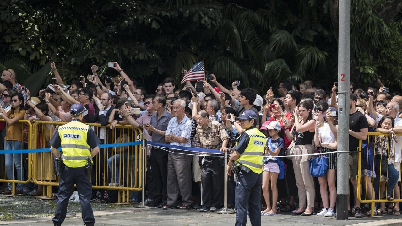 Zahlreiche Menschen versammmeln sich vor der Ankunft von US-Präsident Trump dem Präsidentenpalast in Singapur.