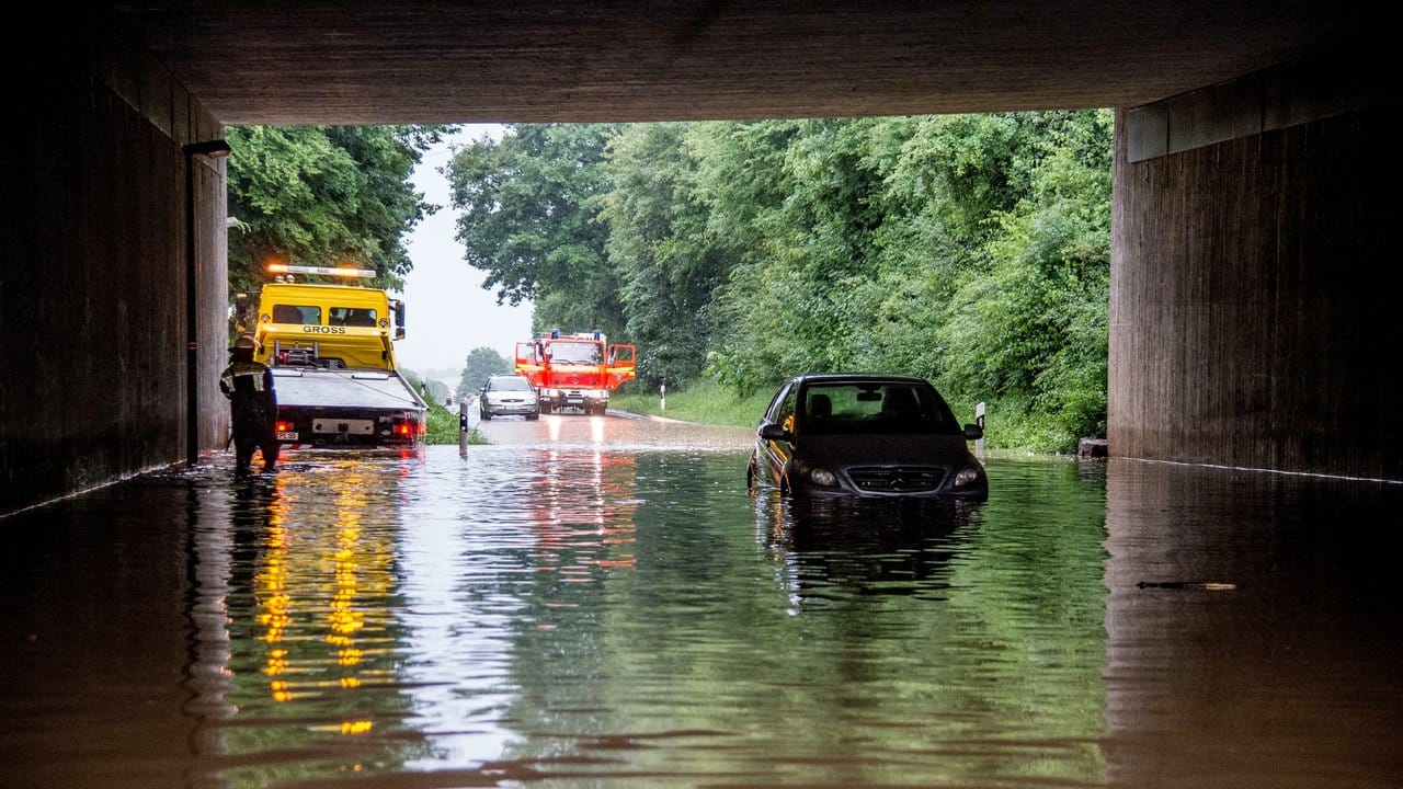 Ein Auto wird in Baden-Württemberg aus einer überfluteten Unterführung gezogen.