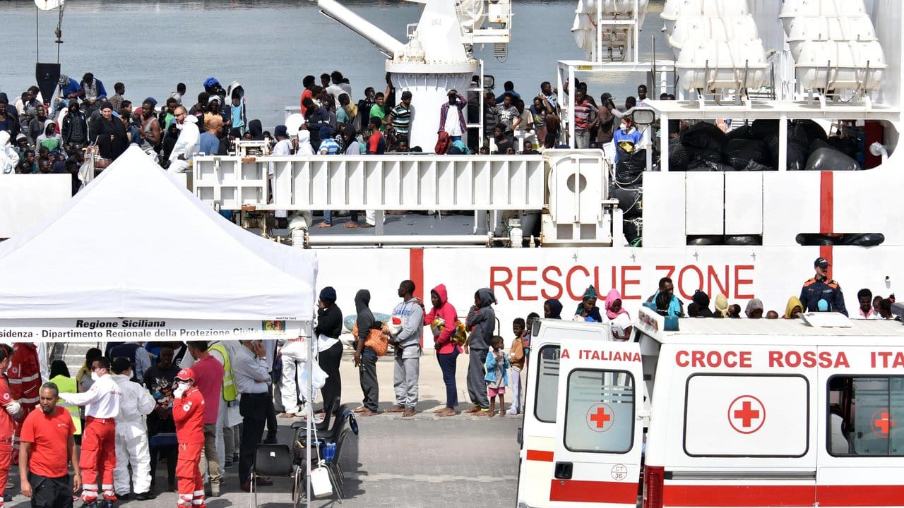 Flüchtlinge warten auf einen Gesundheitscheck, nachdem sie auf dem Schiff "Diciotti" der italienischen Küstenwache die sizilianischen Stadt Catania erreichten.