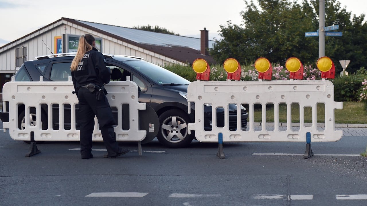 Eine Polizistin spricht mit einem Autofahrer vor einer Straßensperrung in Oberhausen.