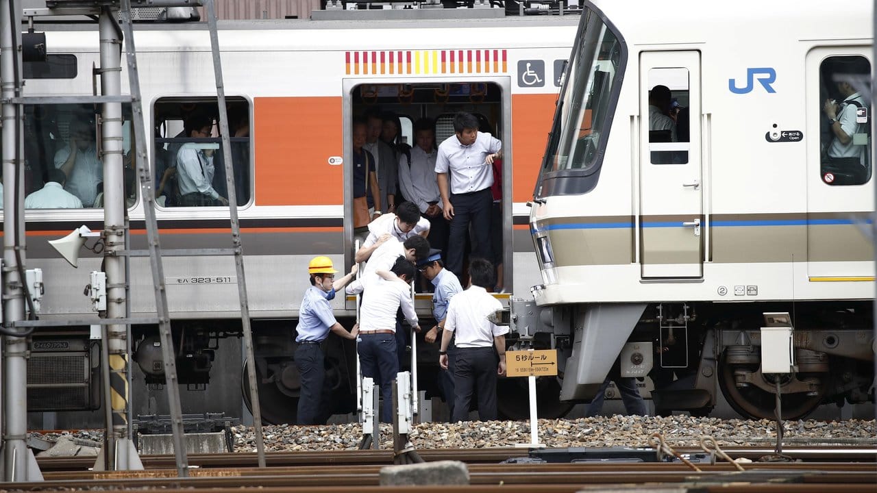 Passagiere steigen in Osaka auf die Gleise, nachdem ihr Zug gestoppt wurde.