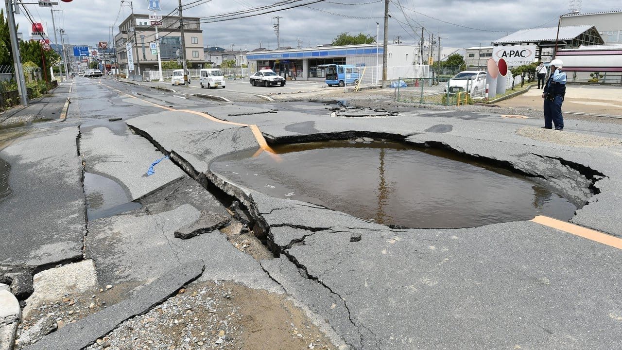 Ein mit Wasser gefüllter Krater auf einer Straße in Takatsuki.