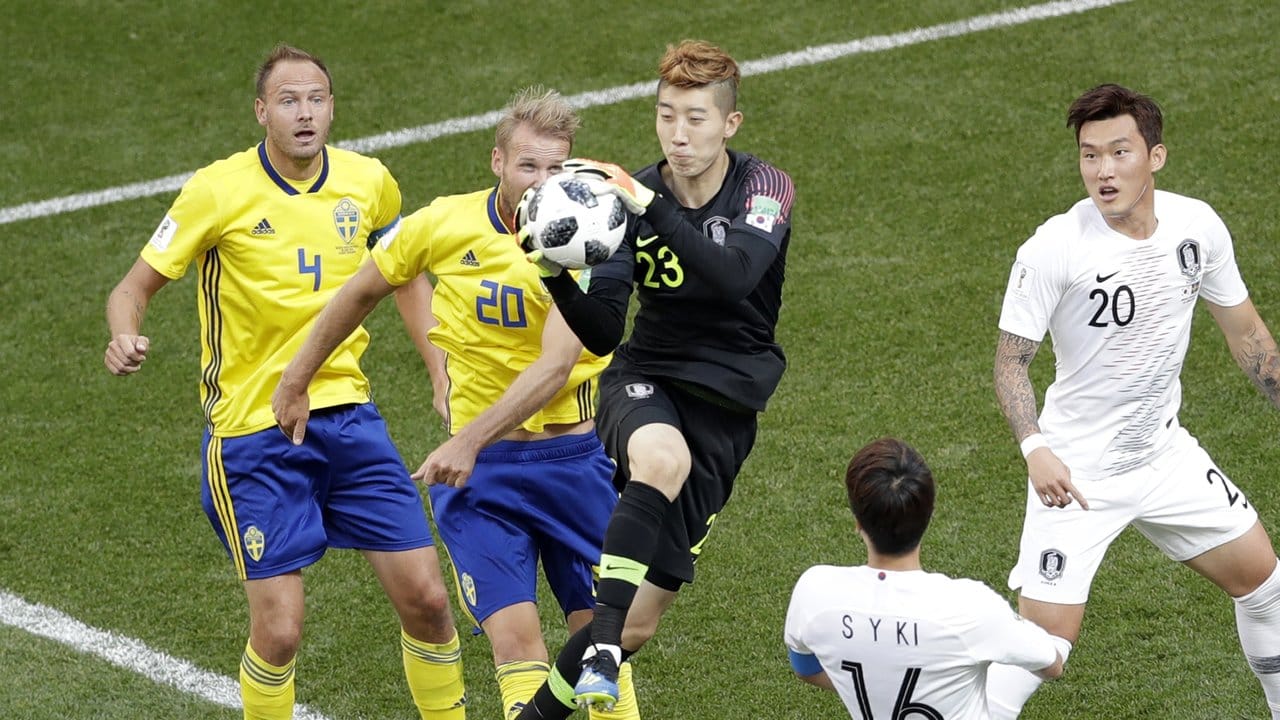 Südkoreas Torhüter Hyeonuh Jo (M) fängt den Ball vor den bereitstehenden Schweden.