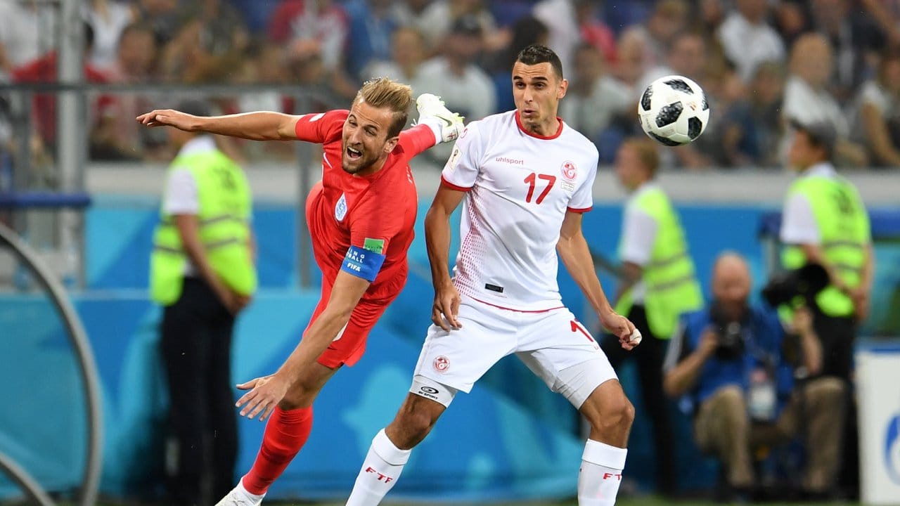 Englands Harry Kane (l) kommt vor dem Tunesier Ellyes Skhiri zum Kopfball.