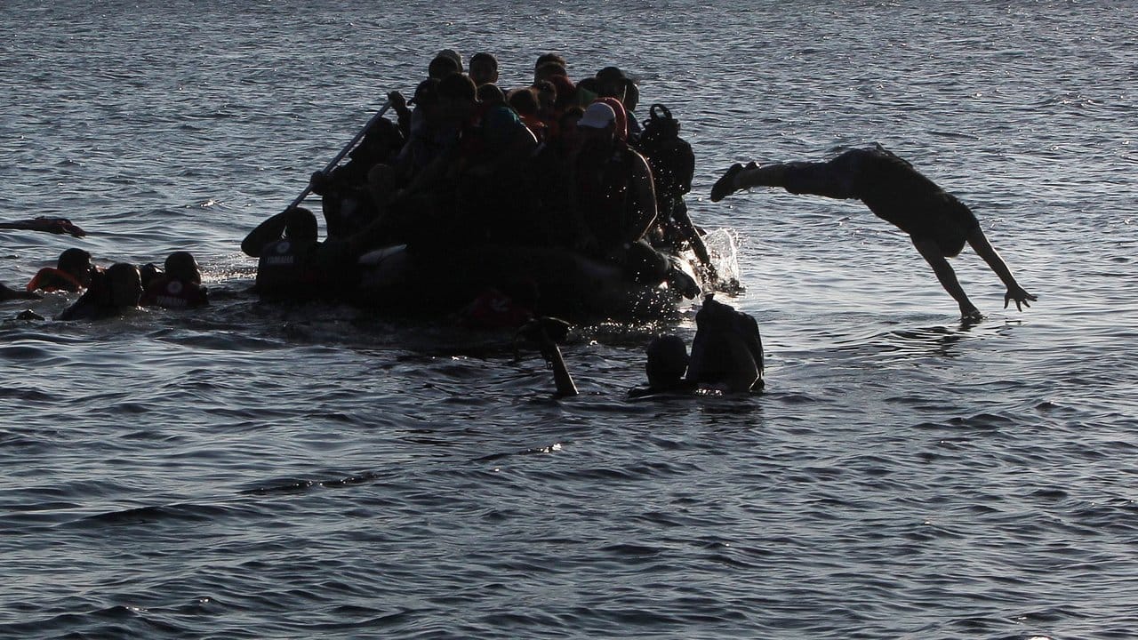 Syrische Migranten springen aus dem Schlauchboot um in Richtung der griechischen Insel Kos zu schwimmen.
