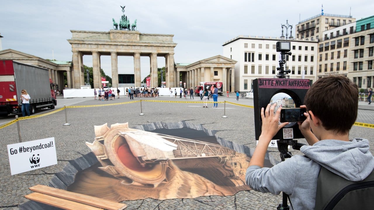 Mit dem 3D-Bild eines Braunkohletagebaus protestieren Umweltschützer in Berlin für eine Veränderung der Umweltpolitik.