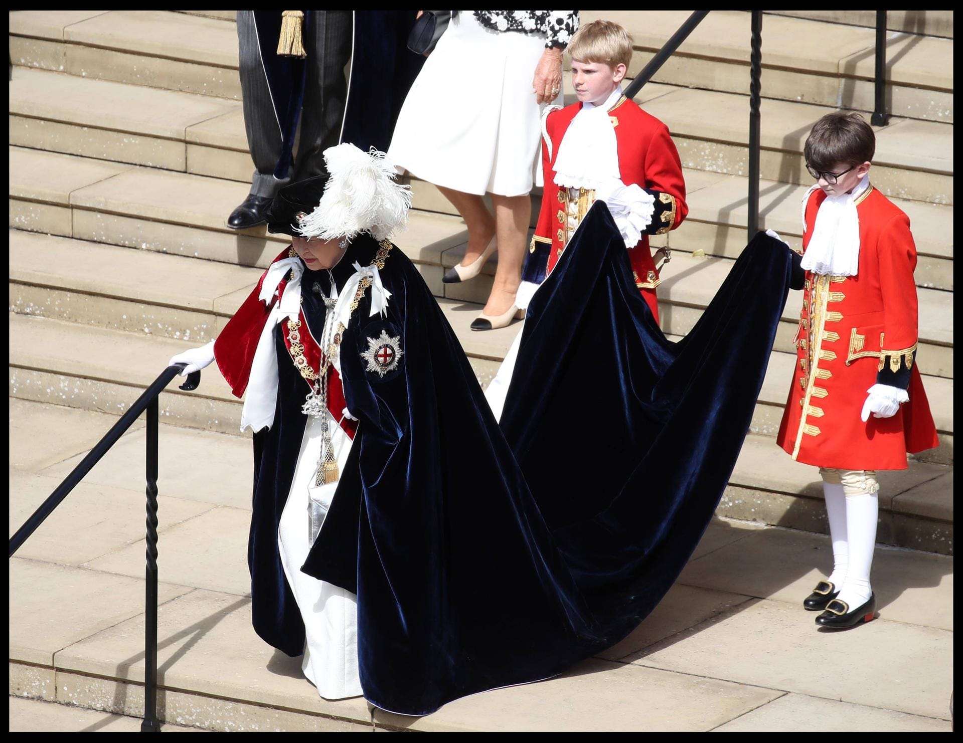 Großer Auftritt: Zwei Kinder tragen den Samt-Mantel der Queen.