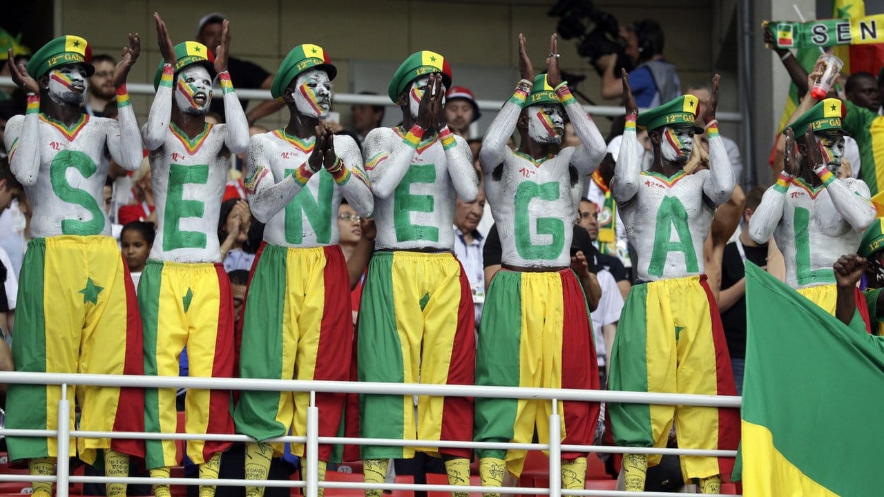 Farbenfroh geschminkte senegalesische Fans bejubeln und beklatschen den Auftritt ihrer Nationalmannschaft.