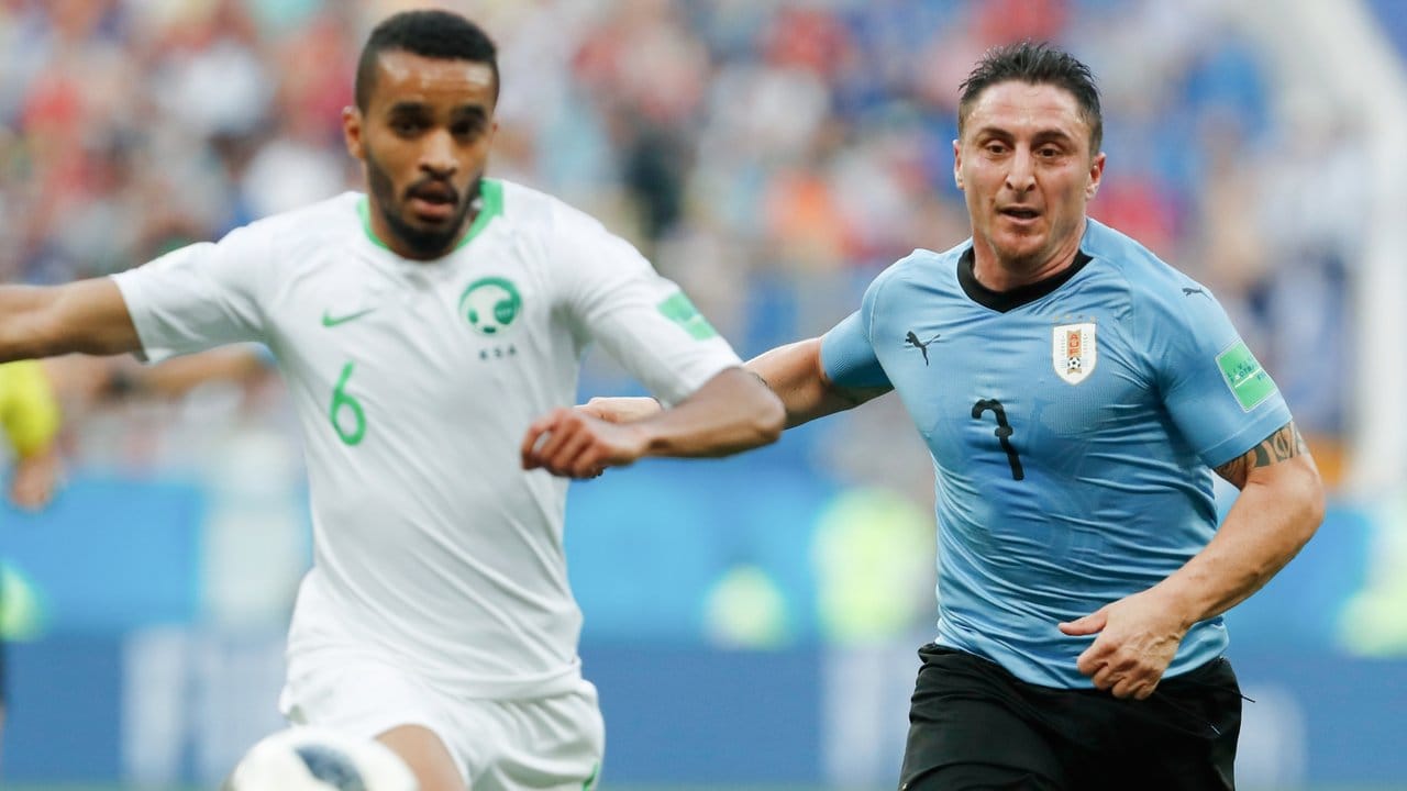 Saudi-Arabiens Mohammed Al-Buraik (l) versucht vor Uruguays Cristian Rodriguez an den Ball zu kommen.
