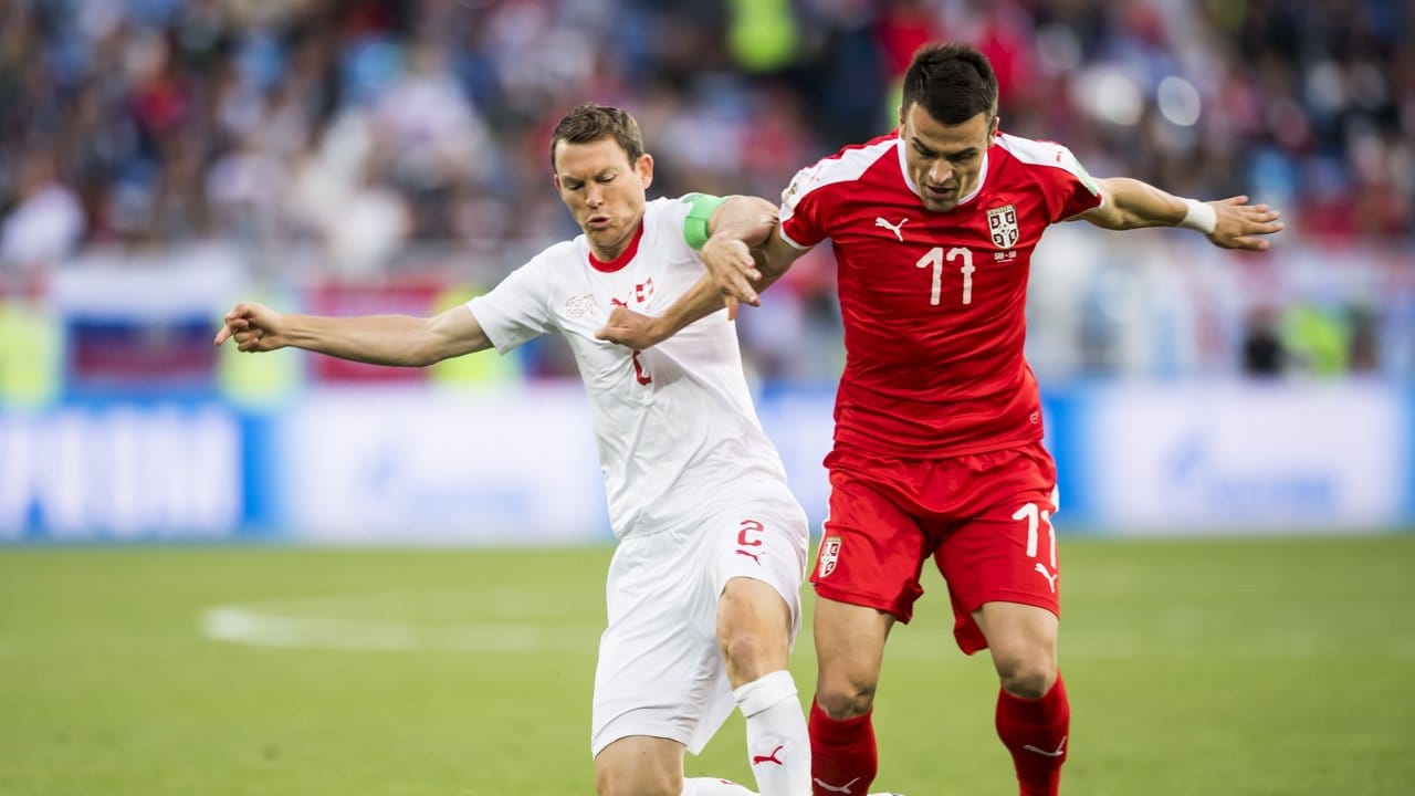 Der Schweizer Teamkapitän Stephan Lichtsteiner (l) und Serbiens Filip Kostic kämpfen um den Ball. Der Schweizer Teamkapitän Stephan Lichtsteiner (l) und Serbiens Filip Kostic kämpfen um den Ball.