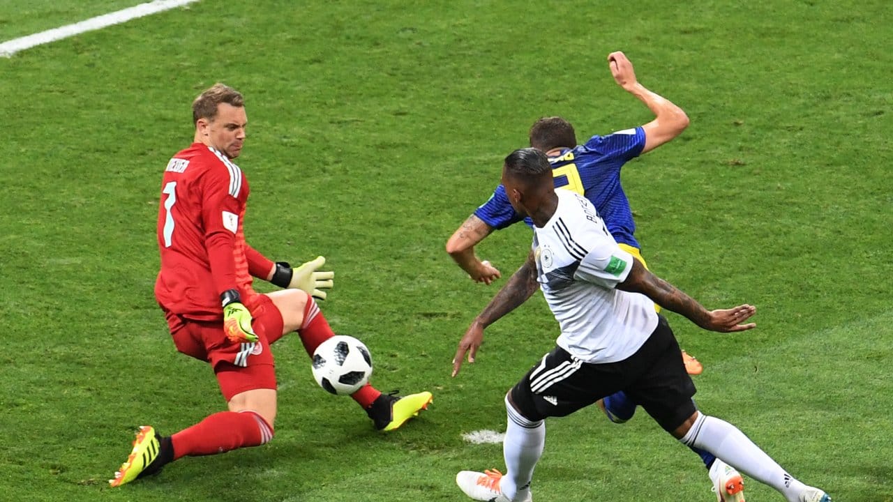 Torwart Manuel Neuer (l) und Jerome Boateng (vorn) mit Körpereinsatz können den auf das deutsche Tor zustrebenden Schweden Marcus Berg aufhalten.