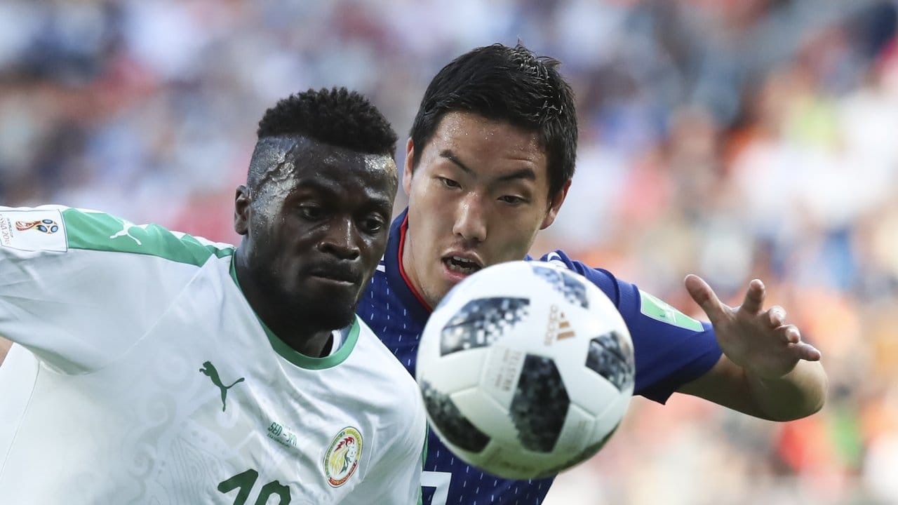 Senegals M'Baye Niang aus Senegal (l) kämpft mit Gen Shoji aus Japan um den Ball.