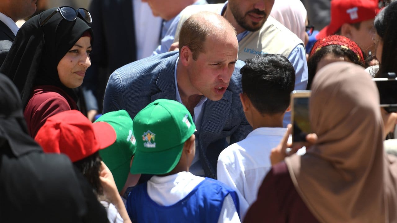 Der britisch Prinz William (M) unterhält sich in Dscharasch mit einheimischen Kindern.