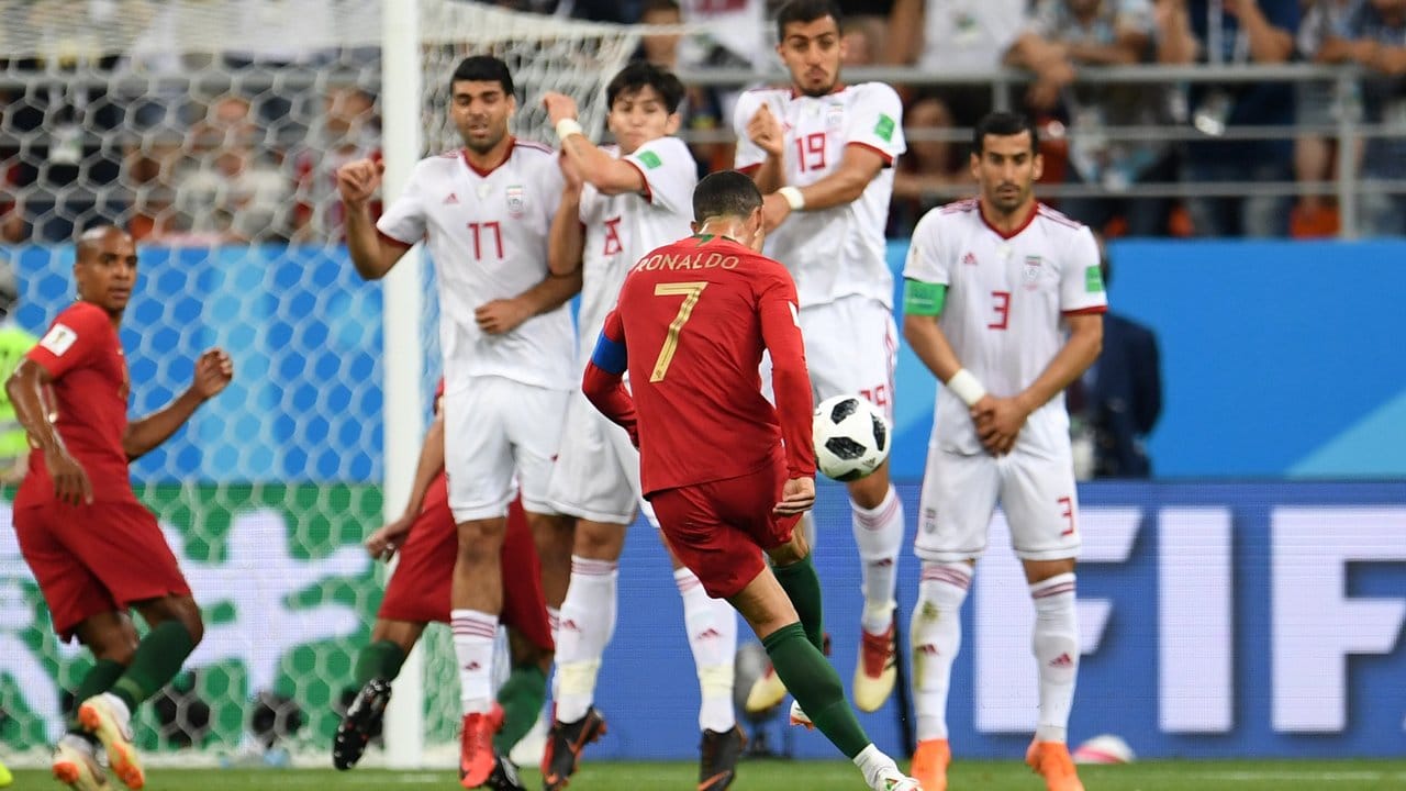Der Ball von Cristiano Ronaldo (M/7) wird abgefälscht und geht über das iranische Tor.