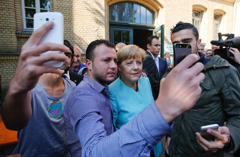 Szenen, die sie noch verfolgen werden: Merkel stellt sich im September 2015 zum Selfie mit Geflüchteten aus Syrien und dem Irak. Kurz zuvor hat sie angewiesen, dass Deutschland die Grenzen nicht schließt für die Massen, die in Ungarn unter miserablen Umständen festhängen. Sie habe die Flüchtlinge eingeladen, wird es später von ihren Kritikern heißen.