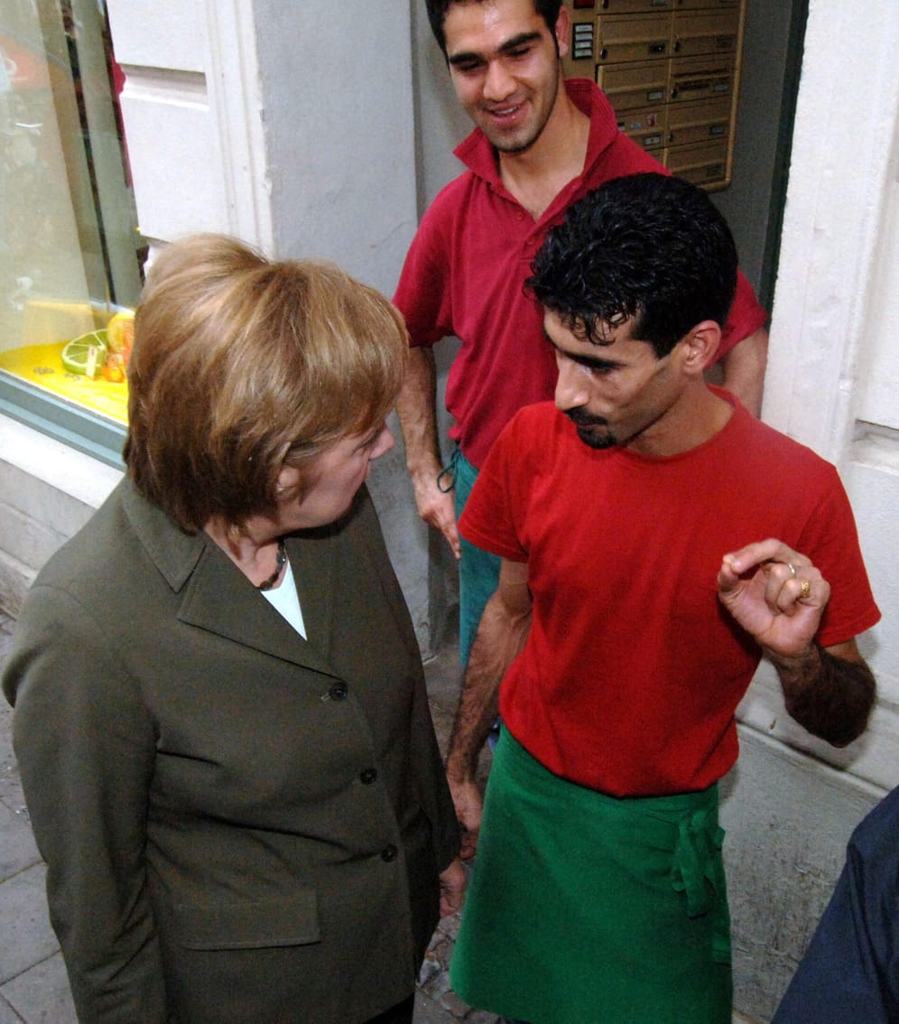 Oppositionspolitikerin Merkel, hier mit einem türkischen Imbisstand-Besitzer, äußerte sich 2004 sehr kritisch zum Thema Integration: "Die multikulturelle Gesellschaft ist gescheitert“, sagte sie in einer Rede am 20. November 2004. Sie sprach von Leitkultur und kritisierte vor allem den aus ihrer Sicht mangelnden Integrationswillen der Muslime.