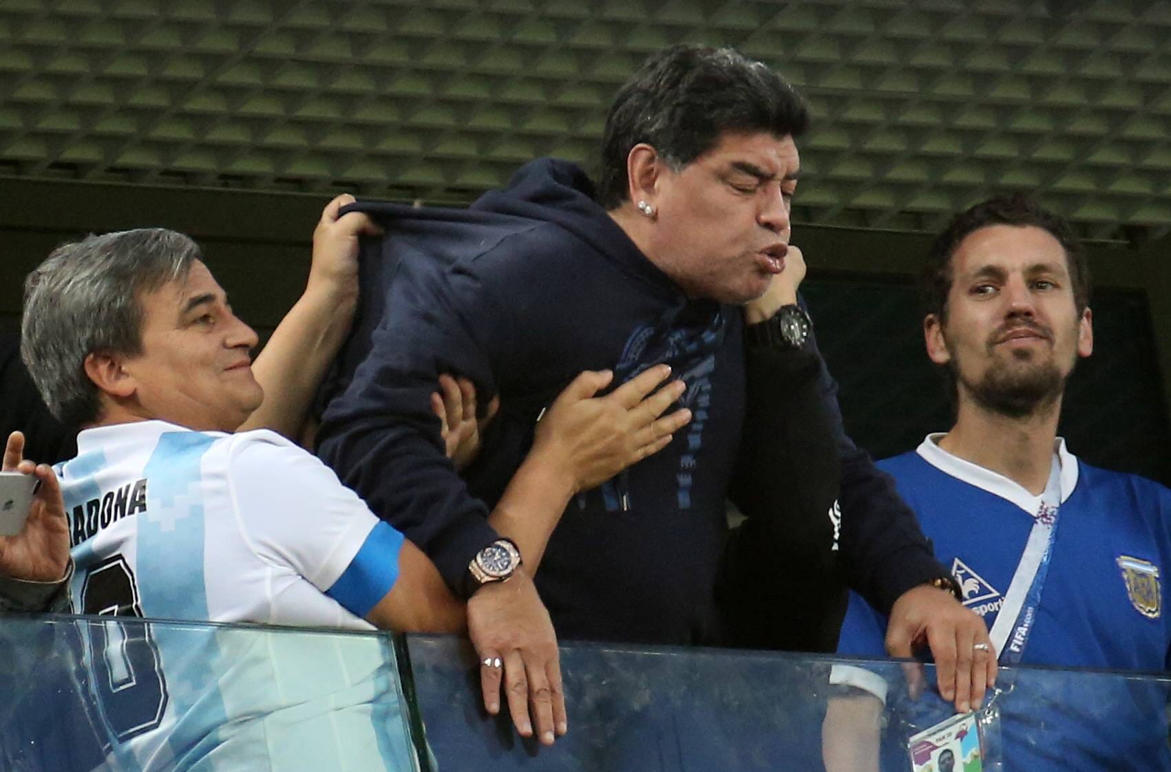 Maradona völlig außer sich: Seine Begleiter unterstützen und lächeln gedrückt.