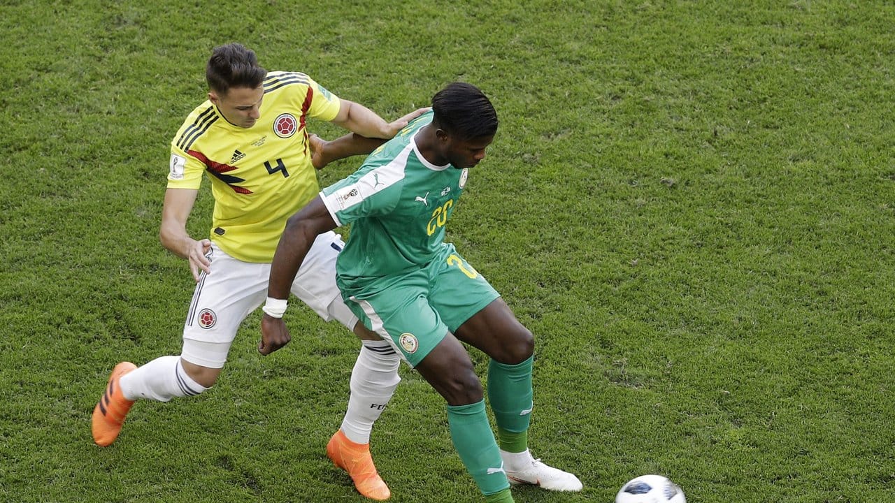Senegals Keita Balde schirmt den Ball vor Kolumbiens Santiago Arias (l) ab. Senegals Keita Balde schirmt den Ball vor Kolumbiens Santiago Arias (l) ab.
