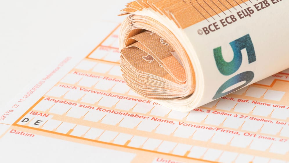 Überweisungsträger und Euro-Noten: Für Auslandsüberweisungen können Gebühren fällig werden. Ob und in welcher Höhe hängt von einigen Bedingungen ab.