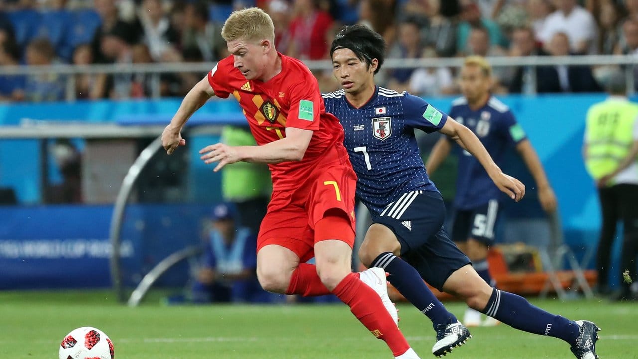 Kevin De Bruyne (l) kommt vor Japans Gaku Shibasaki an den Ball.