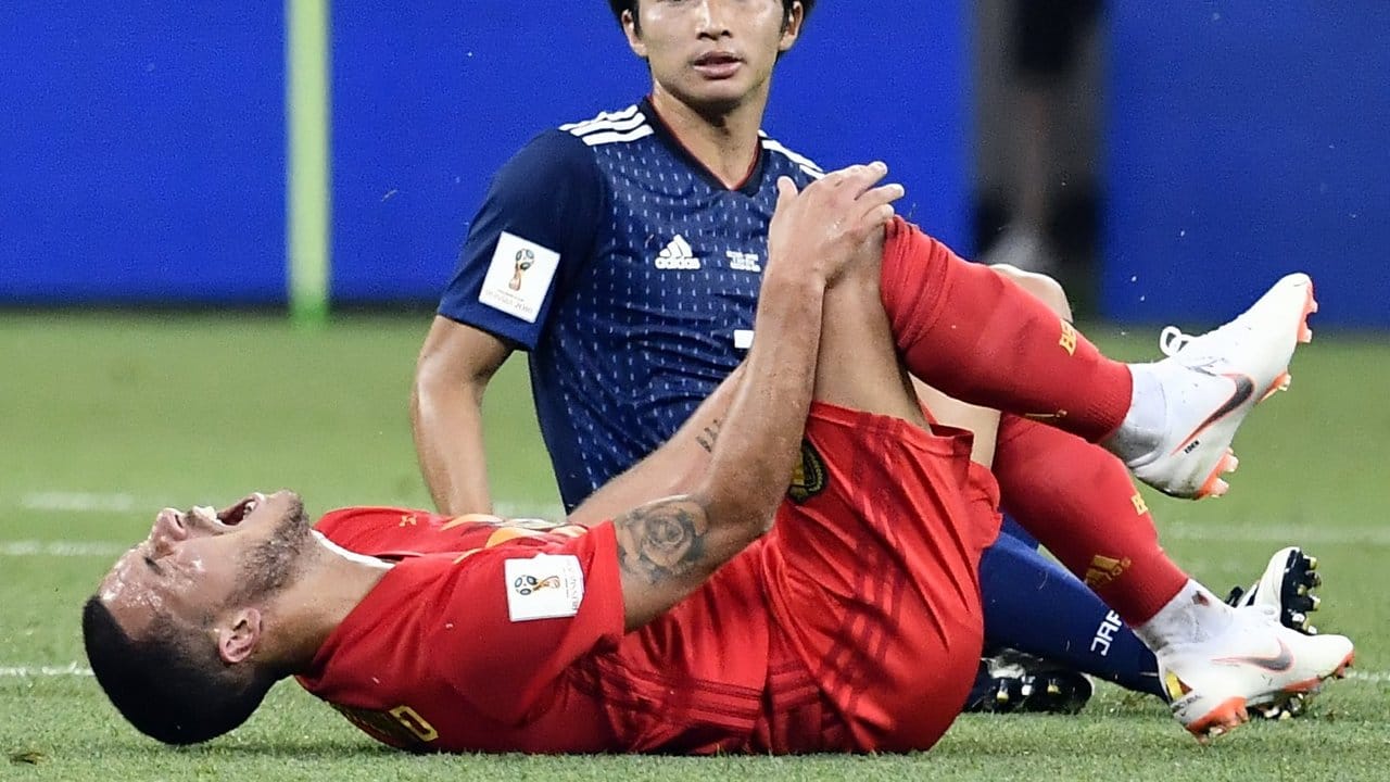 Belgiens Eden Hazard (vorn) liegt nach einem Foul des erschreckt schauenden Japaners Gaku Shibasaki am Boden.