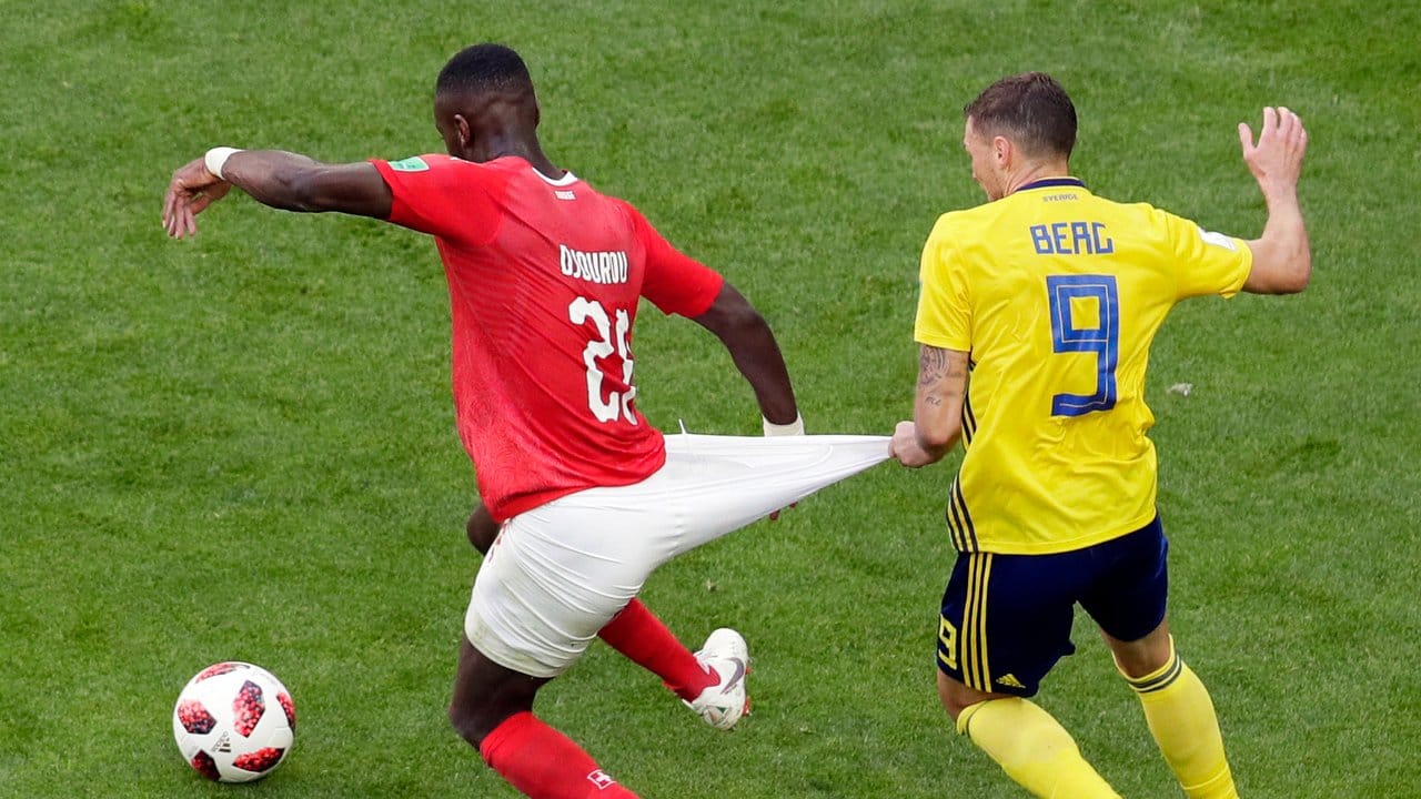 Der Schwede Marcus Berg (r) unterzieht im Zweikampf um den Ball die Schorts vom Schweizer Johan Djourou einem Belastungstest. Der Schwede Marcus Berg (r) unterzieht im Zweikampf um den Ball die Schorts vom Schweizer Johan Djourou einem Belastungstest.