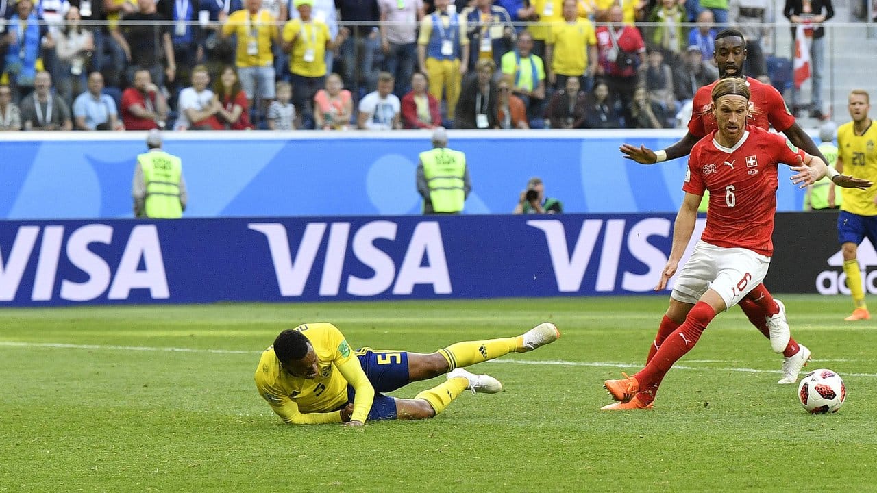 Nach einem Schubser vom Schweizer Michael Lang (r) fällt der Schwede Martin Olsson im Strafraum vor Torwart Yann Sommer (l) zu Boden: Rot für Lang und Freistoß kurz vor dem Abpfiff. Nach einem Schubser vom Schweizer Michael Lang (r) fällt der Schwede Martin Olsson im Strafraum vor Torwart Yann Sommer (l) zu Boden: Rot für Lang und Freistoß kurz vor dem Abpfiff.