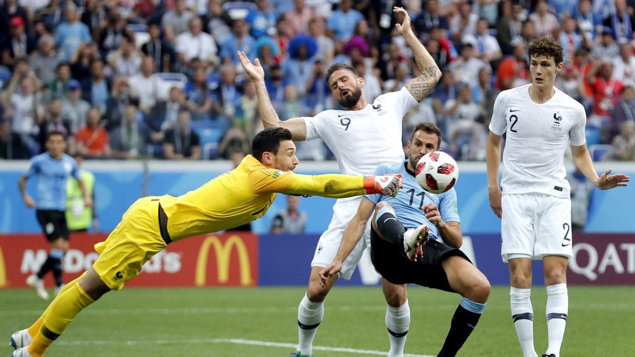 Frankreichs Torwart Hugo Lloris (l) faustet den Ball vor Uruguays Stürmer Stuani weg.
