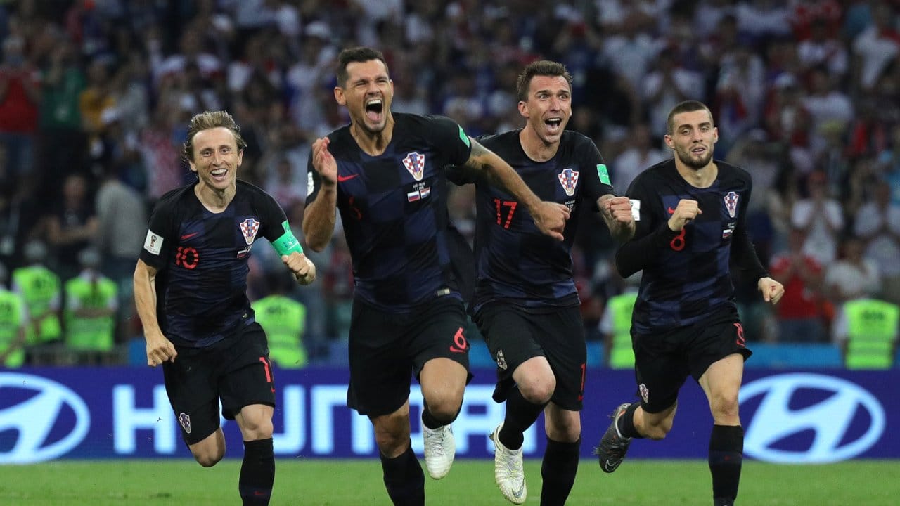 Nach dem gewonnenen Elfmeterschießen gegen Russland laufen die Spieler Kroatiens jubelnd über das Spielfeld. Nach dem gewonnenen Elfmeterschießen gegen Russland laufen die Spieler Kroatiens jubelnd über das Spielfeld.