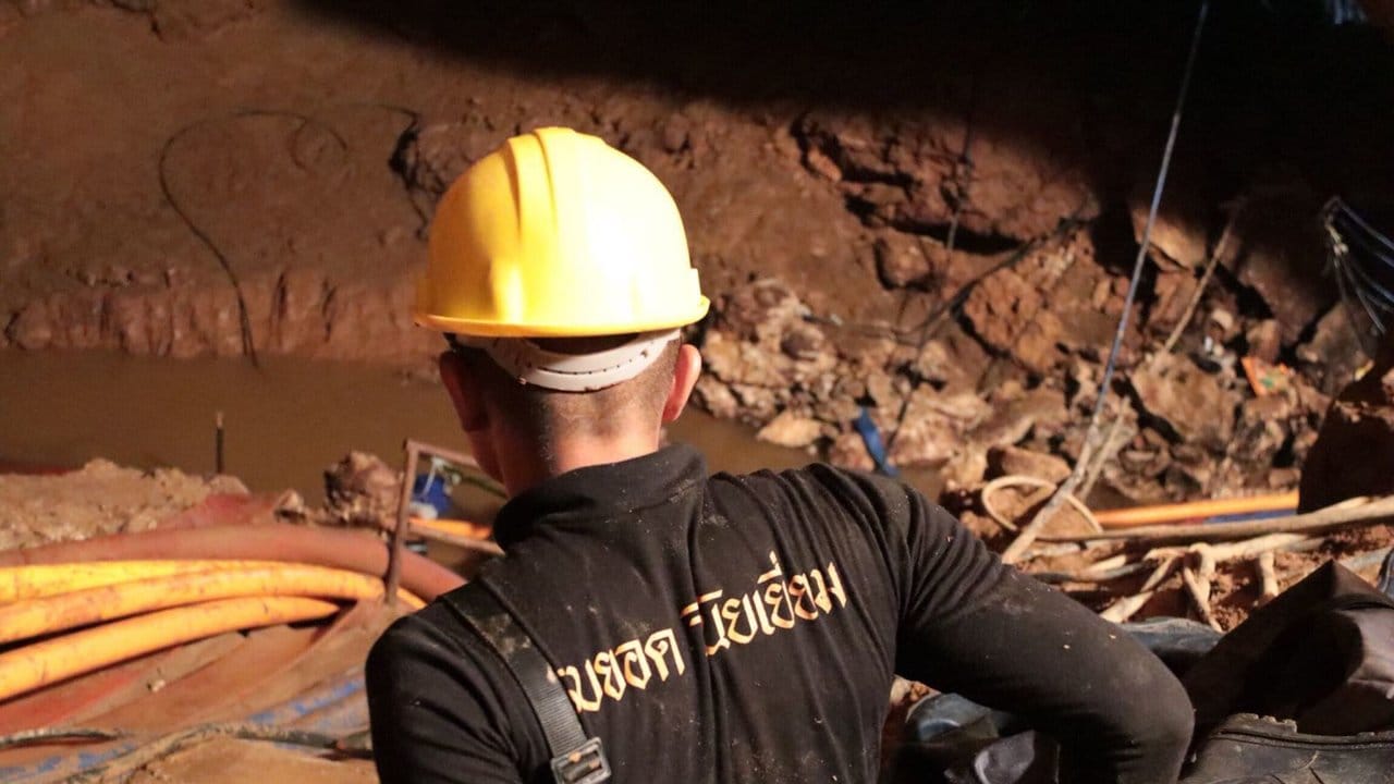 Aus dem Inneren der Höhle: Ein Mitglied des thailändischen Rettungsteam geht in die teilweise geflutetet Höhle hinein.