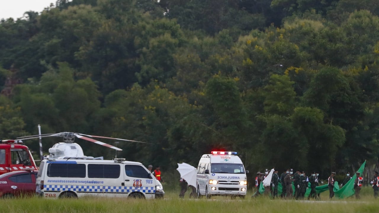 Die letzten geretteten Jungen samt ihrem Trainer werden zu einem Helikopter gebracht.