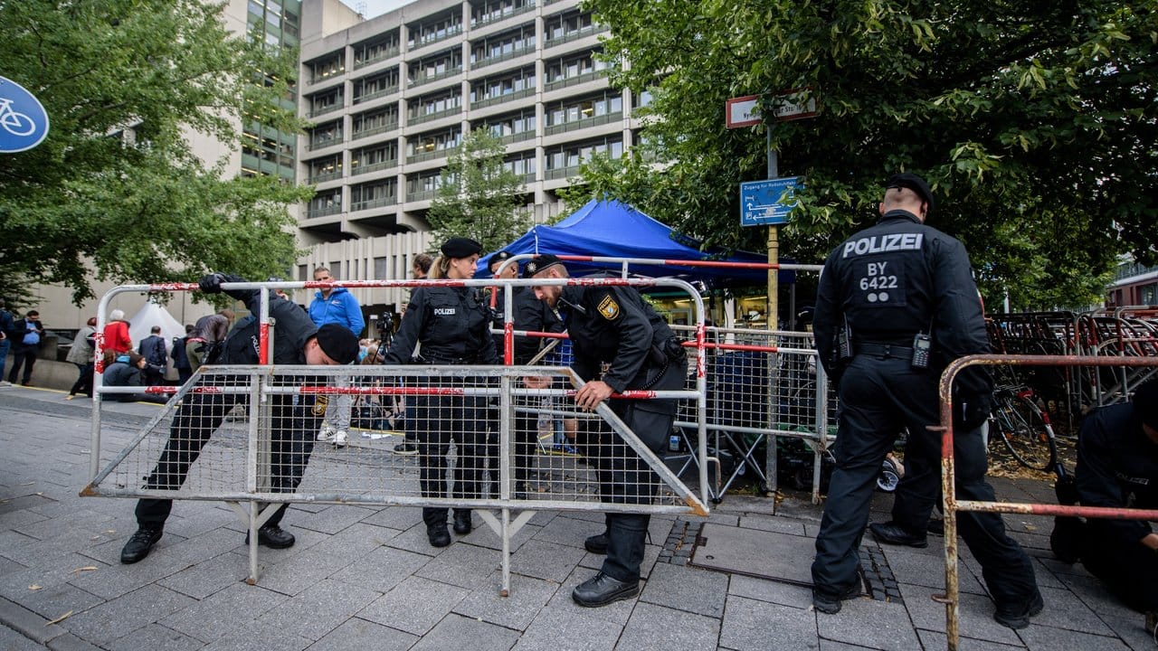 Polizisten stellen vor dem Oberlandesgericht in München Zäune auf.