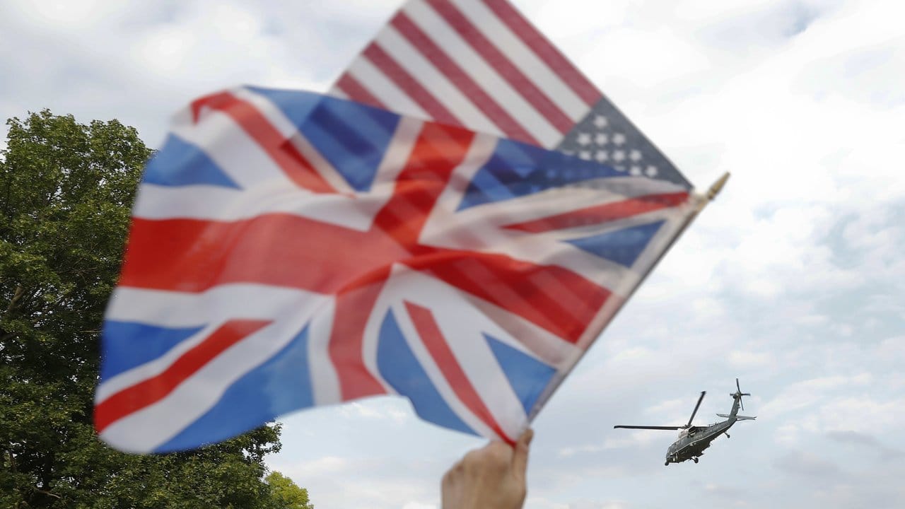 London: Während am Himmel der Helikopter Marine One mit US-Präsident Trump an Bord vorüberfliegt, werden unten eine britische und eine us-amerikanische Flagge geschwenkt.