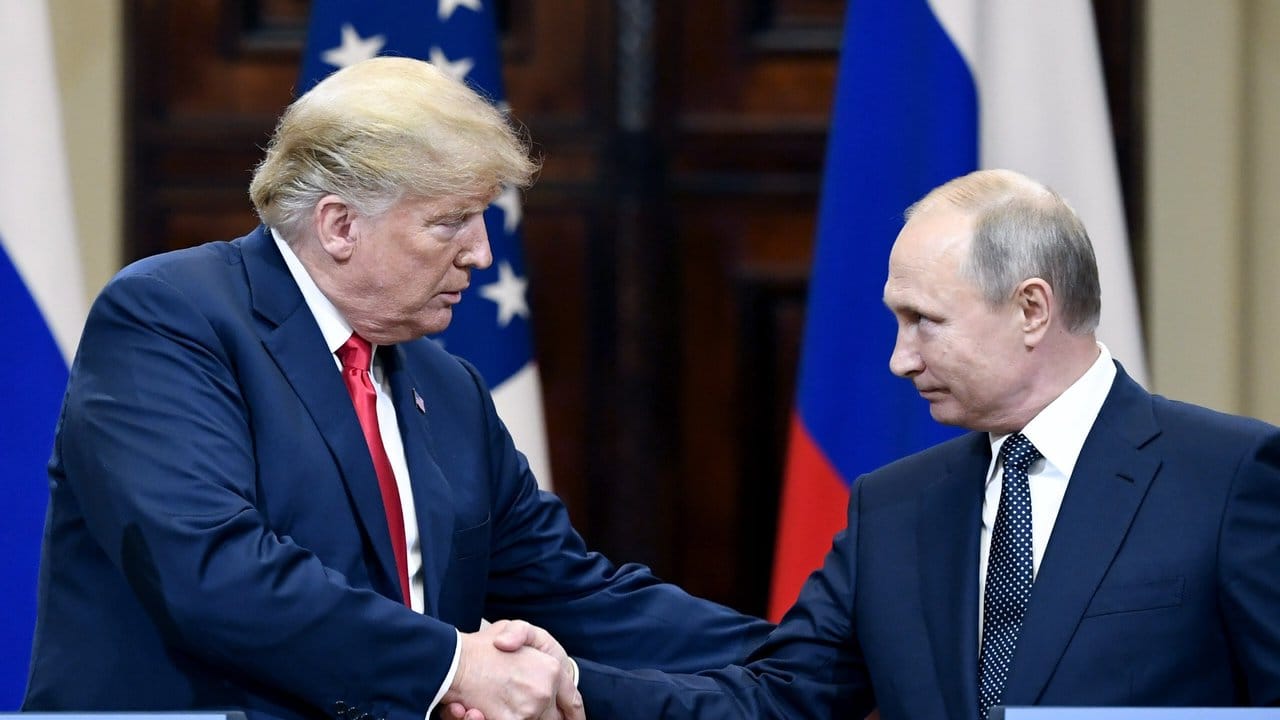 US-Präsident Donald Trump (l) und der russische Staatspräsident Wladimir Putin geben sich die Hand.