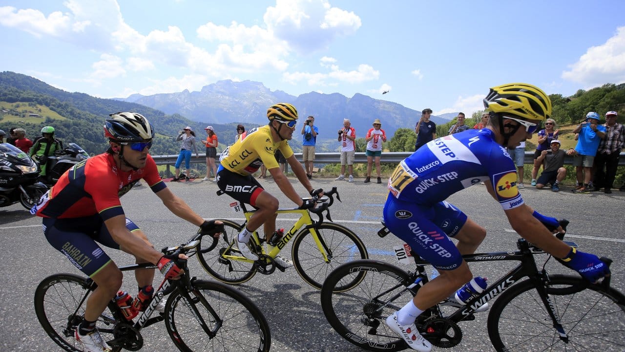 Greg Van Avermaet (M) im Gelben Trikot fährt beim Aufstieg auf den Col de la Croix Fry Bergpass hinter Julian Alaphilippe (r).